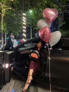 Birthday celebration with balloons and an exotic car
